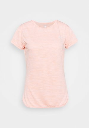 Camiseta de manga corta en color melocotón claro con una textura de rayas sutil, cuello redondo y un pequeño logo en la parte superior izquierda.