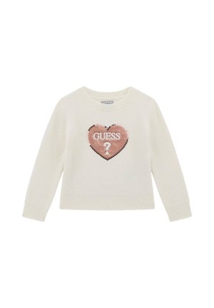 Maglione color crema con una texture morbida, caratterizzato da una patch a forma di cuore con paillettes di un rosa chiaro, sopra la quale è scritto "GUESS" e un punto interrogativo.