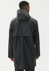 Cseppálló fekete esőkabát kapucnival, hátsó vállrész részlettel, hosszú ujjakkal és állítható mandzsettákkal. Simább, fényes anyag.