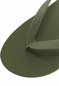 Olivengrøn flip-flop med teksturert såle og tynne, rillede stropper. Laget av gummimateriale, med en sirkulær form og et sentralt dreiepunkt.
