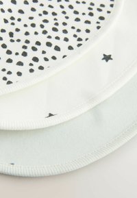 Ensemble de trois bavoirs en coton présentant des pois noirs, des étoiles et un doux vert pâle. Forme circulaire avec des bords texturés pour une durabilité accrue.