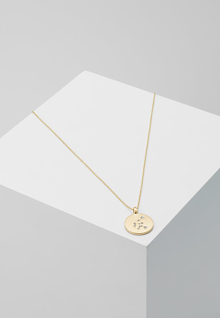 Collana con pendente in oro con ciondolo rotondo caratterizzato da un piccolo design di costellazione stellare incisa, sospeso su una fine catena.