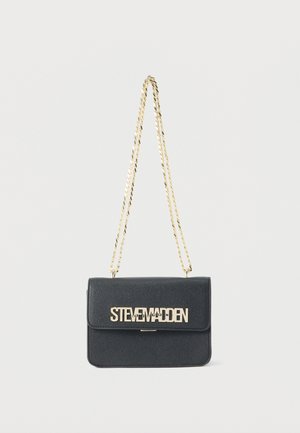 Musta suorakaiteen muotoinen olkalaukku, jossa on kullanvärinen ketjuhihna ja kullanvärinen "Steve Madden" -logo etutaskun läpissä valkoista taustaa vasten.