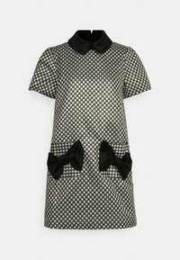 Svart och vit houndsandrake kort klänning med svart krage, som har två framfickor prydda med svarta sammetssnören.