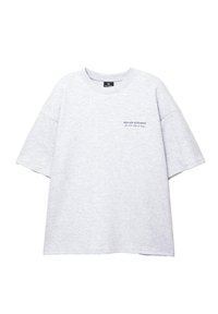 Grå oversized t-shirt lavet af bomuld, med rund halsudskæring og korte ærmer. "NEW AGE MOVEMENTS" trykt i mørke bogstaver på brystet.