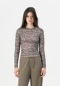 Langsleeve top met een sheer, lichtgewicht stof in een beige en bruine zebra-streep patroon, gecombineerd met relaxed fit olijfgroene broek.