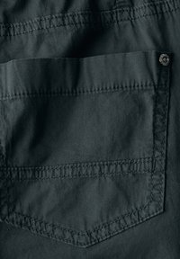Dark gray fabric features a patch pocket with visible stitching and a metallic snap button accent on the side. Smooth texture.