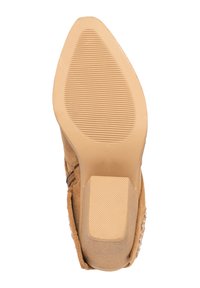 Suela de zapato de ante beige con una superficie de goma texturizada, que presenta un pequeño tacón y una zona trasera lisa y plana para mayor estabilidad.