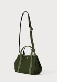 Borsa a giorno strutturata di colore verde scuro con manici corti e tracolla lunga regolabile, posizionata su uno sfondo bianco uniforme.