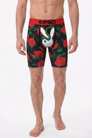 Hombre con bóxers negros con rosas rojas, un logo blanco del conejo de Playboy, un gráfico de serpiente verde y una cintura roja con la etiqueta PSD.