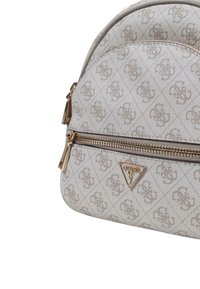 Beige textured handbag with a gold zipper and hardware, featuring a diamond pattern and a logo triangle accent on the front.