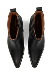 Bottines en cuir noir avec bouts pointus, dotées de fermetures éclair latérales et d'une texture lisse. L'intérieur est doublé d'une couleur fauve contrastante.