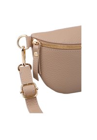 Close-up of beige textured leather bag with gold zipper, gold buckle, and adjustable strap with metal clasp.