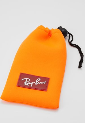 Saco de tecido laranja com fecho por cordão e cordão preto. Apresenta uma etiqueta vermelha com o logótipo branco "Ray-Ban". Textura suave.
