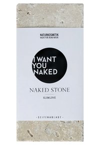 Mydelniczka z naturalnego kamienia, prostokątna, w jasnym beżowym kolorze z teksturowaną powierzchnią. Biała etykieta papierowa z czarnym okrągłym wzorem i napisem.