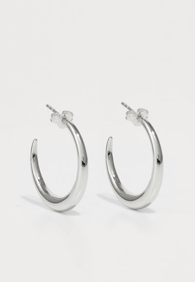 Silver hoop earrings with a smooth, polished surface, featuring a curved design and a secure clasp. Made from metal with a reflective finish.