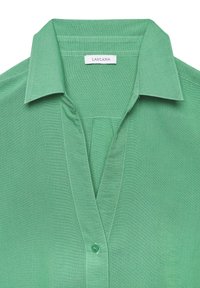 Green collared blouse, lightweight fabric, button at the neckline, featuring a v-neck design with visible stitching details. Lascana tag present.