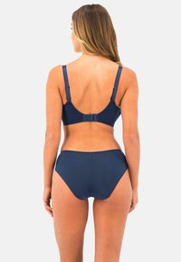 Tummansininen bikinit, joissa on tukevat luukupit, säädettävät olkaimet ja korkeat alaosat, sileää kangasta, jossa on minimaalinen yksityiskohtaisuus.