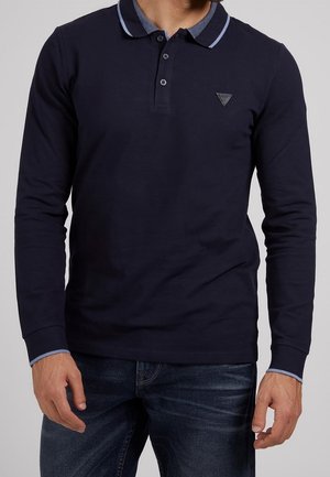 Polo de manga larga en algodón color azul marino con cuello de solapa, cierre de botones y detalles en azul claro en el cuello y los puños. Logotipo triangular en el pecho.