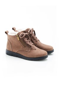 Botas de tobillo de ante marrón con forro de falso pelo, puntera redonda, cordones frontales y cremallera lateral. Presentan una suela de goma negra.