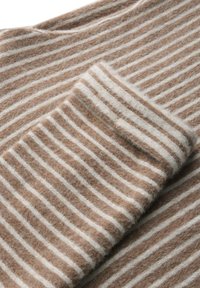 Braun- und cremegestreifter Stoff, weiche Textur, mit horizontalen Linien, mit einer Falte am Rand, die ein kontrastierendes Streifenmuster zeigt.