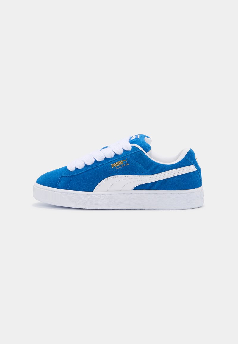Baskets en daim bleu avec des accents blancs, bout arrondi, épais lacets blancs et semelle en caoutchouc texturé. Détail du logo doré sur le côté.