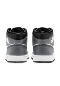 Zapatillas altas de cuero gris con detalles en negro, que presentan una suela blanca, un collar acolchado y un detalle del logo en el talón.