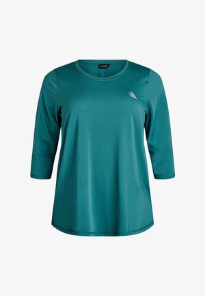 T-shirt à manches longues de couleur sarcelle, fabriqué en tissu lisse, avec un col rond et un petit accent décoratif près de l'épaule.