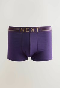 Boxers violets en tissu lisse. La ceinture présente un logo doré "NEXT" avec des rayures d'accent. Coupe ajustée avec une pochette profilée.