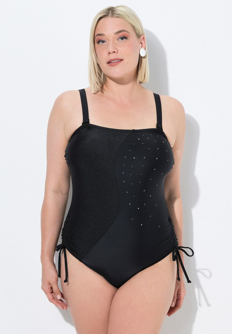 Černé jednodílné plavky s texturovaným třpytivým panelem, bočním řasením a dekorativními kamínky na přední straně. Nastavitelné ramínka a šňůrky po stranách.