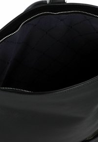 Sac fourre-tout en cuir noir avec une texture lisse, équipé de quincaillerie en argent et d'une doublure intérieure noire avec un motif géométrique subtil.