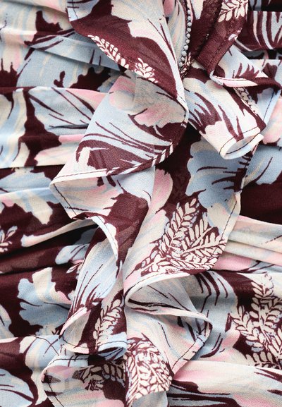 Ύφασμα με απαλές πτυχές, διακοσμημένο με λουλουδένιο μοτίβο σε μπορντό, ανοιχτό μπλε, ροζ και κρεμ αποχρώσεις.