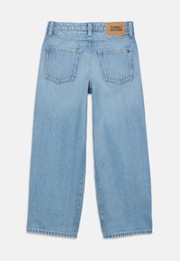 Šviesiai mėlyni tiesaus kirpimo džinsai su dviem užpakalinėmis kišenėmis, Tommy Hilfiger odiniu logotipo ženkleliu ir mažuoju vėliavos logotipu dešinėje kišenėje.