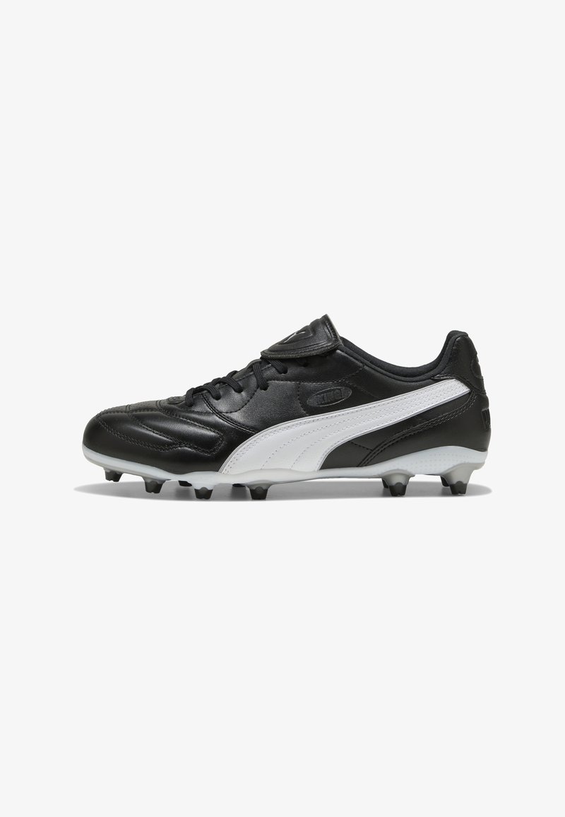 Chaussure de football Puma noire et blanche avec crampons sous la semelle, lacets, et étiquette "King" sur le côté, vue de profil.