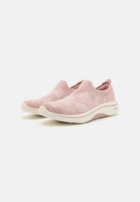 Světle růžové slip-on boty s texturovaným pleteným svrškem, polstrovanou podrážkou a jemnými elastickými akcenty na límci pro flexibilitu.