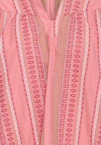 Tissu rose avec des rayures verticales présentant des motifs géométriques en rose foncé, rose clair et beige, avec un col en V central.