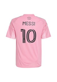 Maillot de football rose en tissu léger. Présente le texte noir "MESSI" et le numéro "10" au dos, avec des accents en maille sur les épaules.