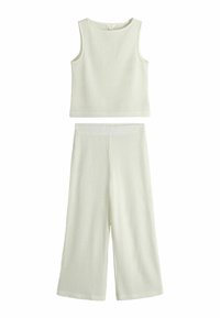 Bílé žebrované crop top bez rukávů spojený se stejnými širokými kalhotami, obojí z texturované látky.