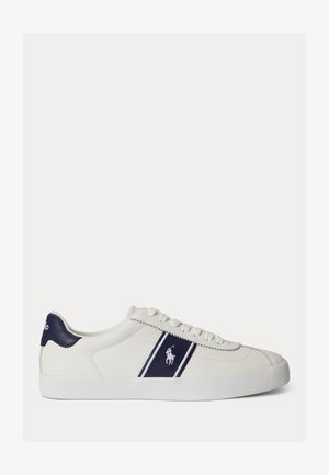 Fehér alacsony szárú sportcipő tengerészkék részletekkel, oldalsó logóval, amely egy pólójátékost ábrázol, és fehér fűzővel, texturált talpon.