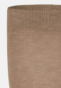 Beige Strumpf aus Strick mit glatter Textur, der oben einen breiten Rippbund hat und durchgehend einheitlich gefärbt ist. Für Komfort und Passform gestaltet.