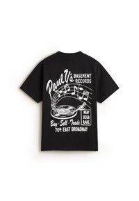 Camiseta de algodón negra con gráficos blancos de un tocadiscos, notas musicales y el texto "Paul V's Basement Records" en la parte posterior.