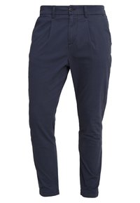 Granatowe chinosy wykonane z bawełnianej mieszanki tkaniny. Charakteryzują się dopasowanym krojem, plisami z przodu oraz standardowym pasem z zapięciem na guzik i kieszeniami.