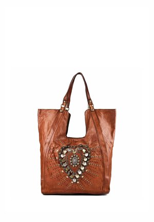 Sac cabas en cuir marron avec deux poignées et un motif décoratif en forme de cœur réalisé avec des clous métalliques et des pièces sur le devant.