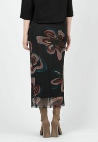 Svart blommig maxikjol med stora, abstrakta blommor i nyanser av rosa och teal. Tillverkad av lättviktsmaterial med en svepande design.