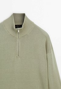 Lichtgroene pullover met een hoge kraag en halve rits. Gemaakt van een gestructureerd breimateriaal, met een schouderverlagend ontwerp en een relaxte pasvorm.