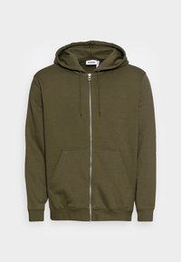 Olivgrüne Zip-Hoodie mit Fronttaschen, verstellbarem Kordelzug an der Kapuze sowie gerippten Bündchen und Saum, auf einem weißen Hintergrund präsentiert.