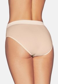 Beżowe majtki wykonane z gładkiego, elastycznego materiału, z szerokim pasem w talii i minimalnym zakryciem z tyłu oraz po bokach.