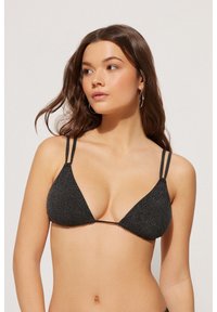 Černý trojúhelníkový plavkový top s třpytivou texturou, tenkými ramínky a minimalistickým designem, zdůrazňující současný styl plavek.