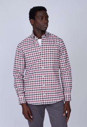 Chemise à carreaux avec des nuances de rouge, blanc et gris. Le tissu est en coton avec une texture lisse, présentant un col classique et des manches longues.