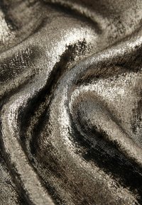 Metallic fabric with a smooth, glossy texture in silver and dark gray hues, featuring subtle ripples and shine across the surface.